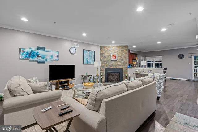 a living room with furniture a flat screen tv and a fireplace