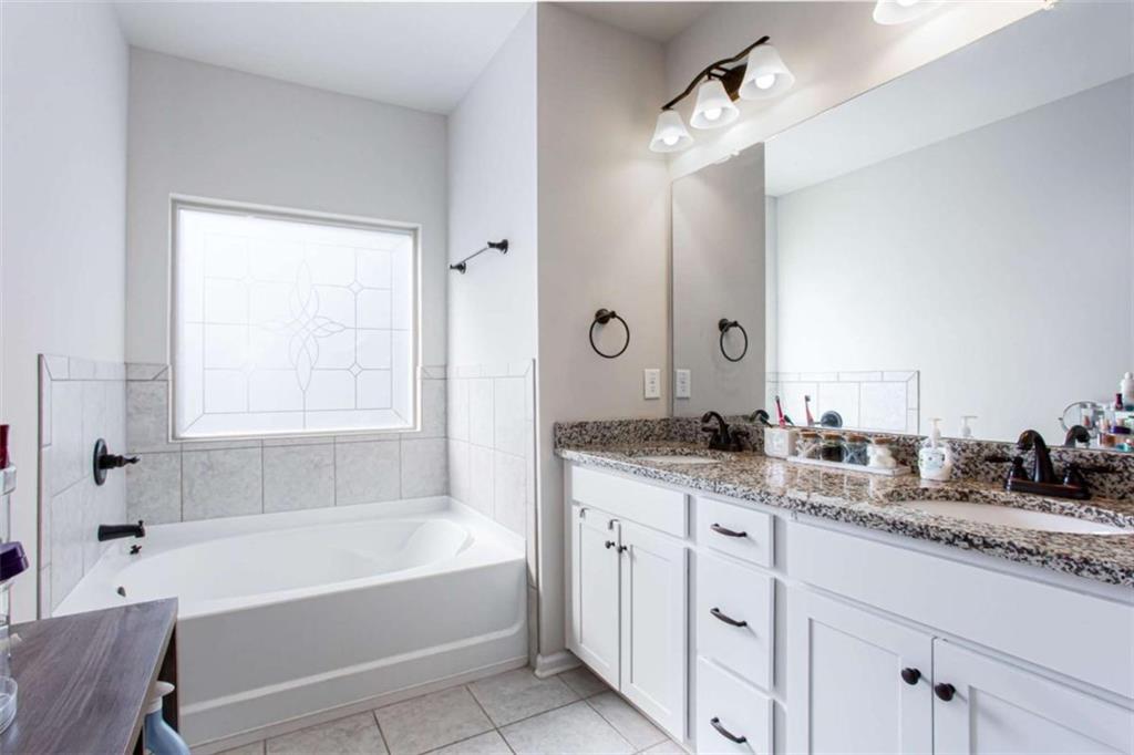 95 Bromes Street Lawrenceville, GA 30046 - Photo 14 of 37 a bathroom with a granite countertop sink mirror bathtub and next to a window