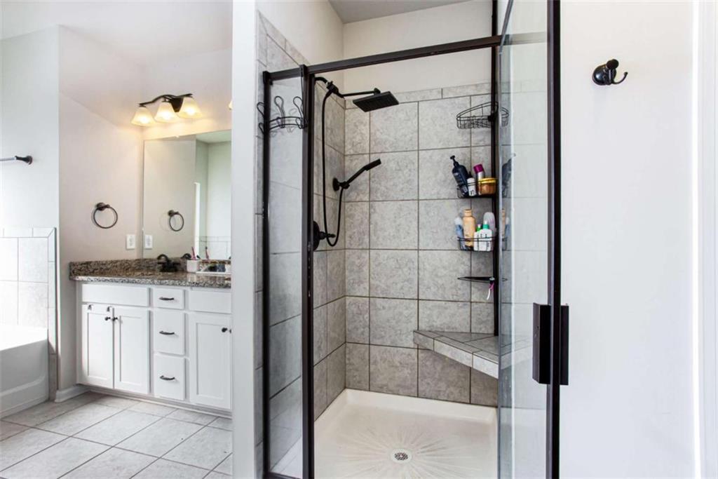95 Bromes Street Lawrenceville, GA 30046 - Photo 16 of 37 a bathroom with a granite countertop sink a mirror and shower
