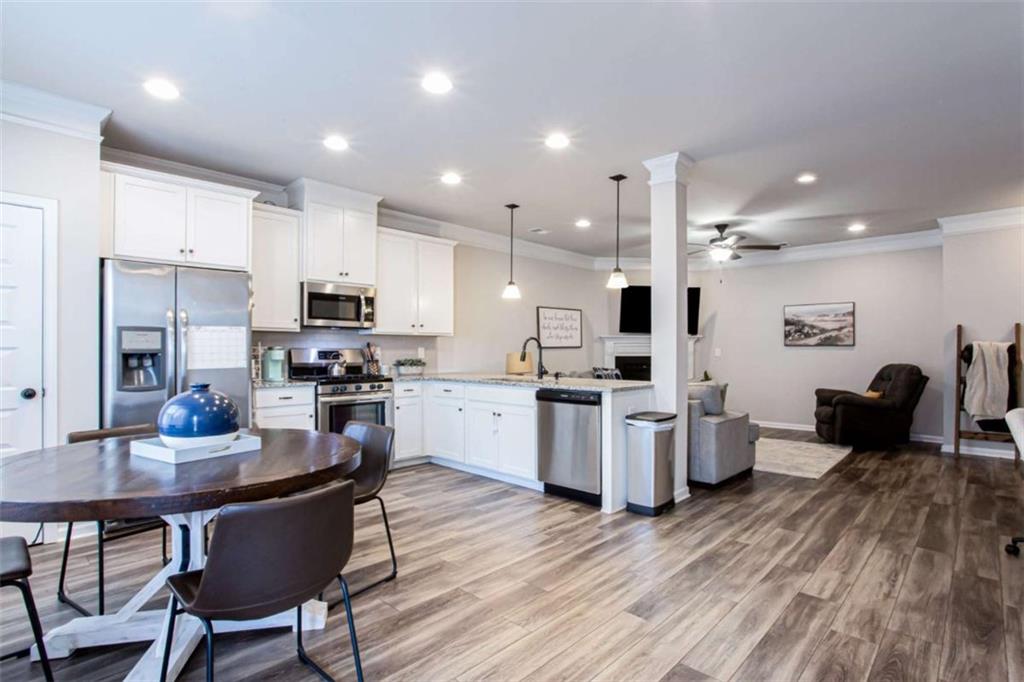 95 Bromes Street Lawrenceville, GA 30046 - Photo 4 of 37 a kitchen with a dining table chairs wooden floor cabinets and appliances