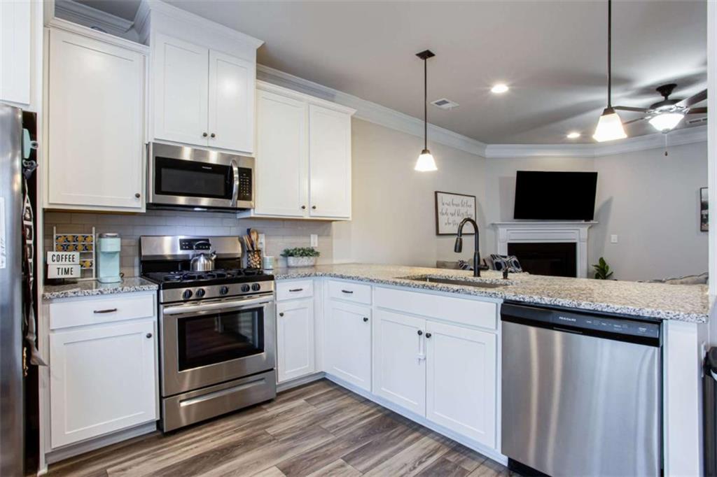 95 Bromes Street Lawrenceville, GA 30046 - Photo 6 of 37 a kitchen with stainless steel appliances granite countertop a stove top oven a sink and a granite counter top