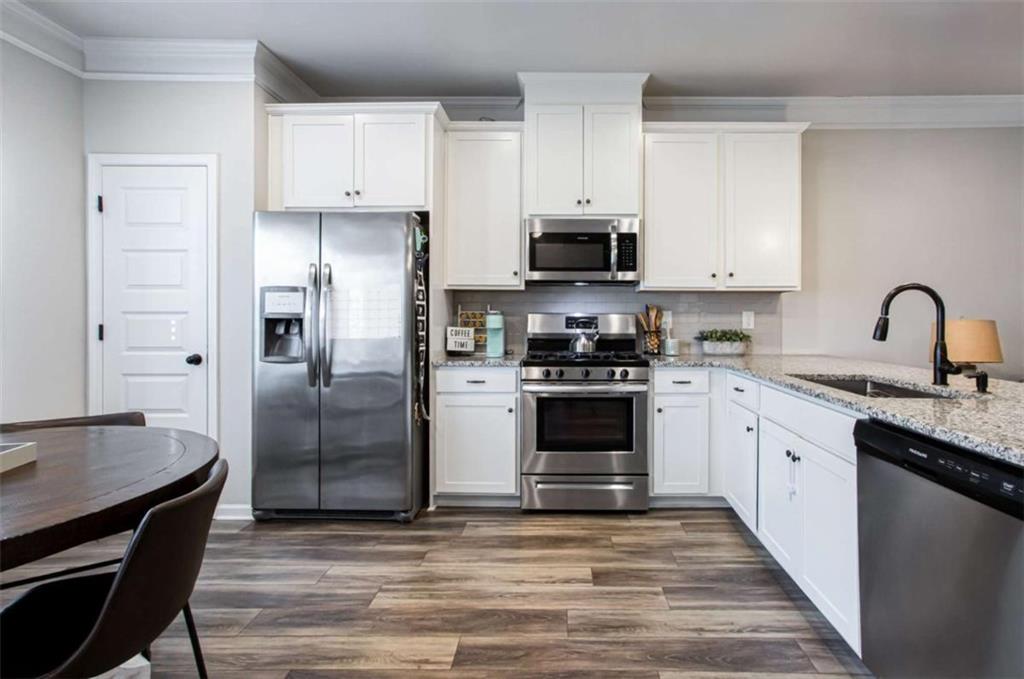 95 Bromes Street Lawrenceville, GA 30046 - Photo 7 of 37 a kitchen with granite countertop a refrigerator stove and sink