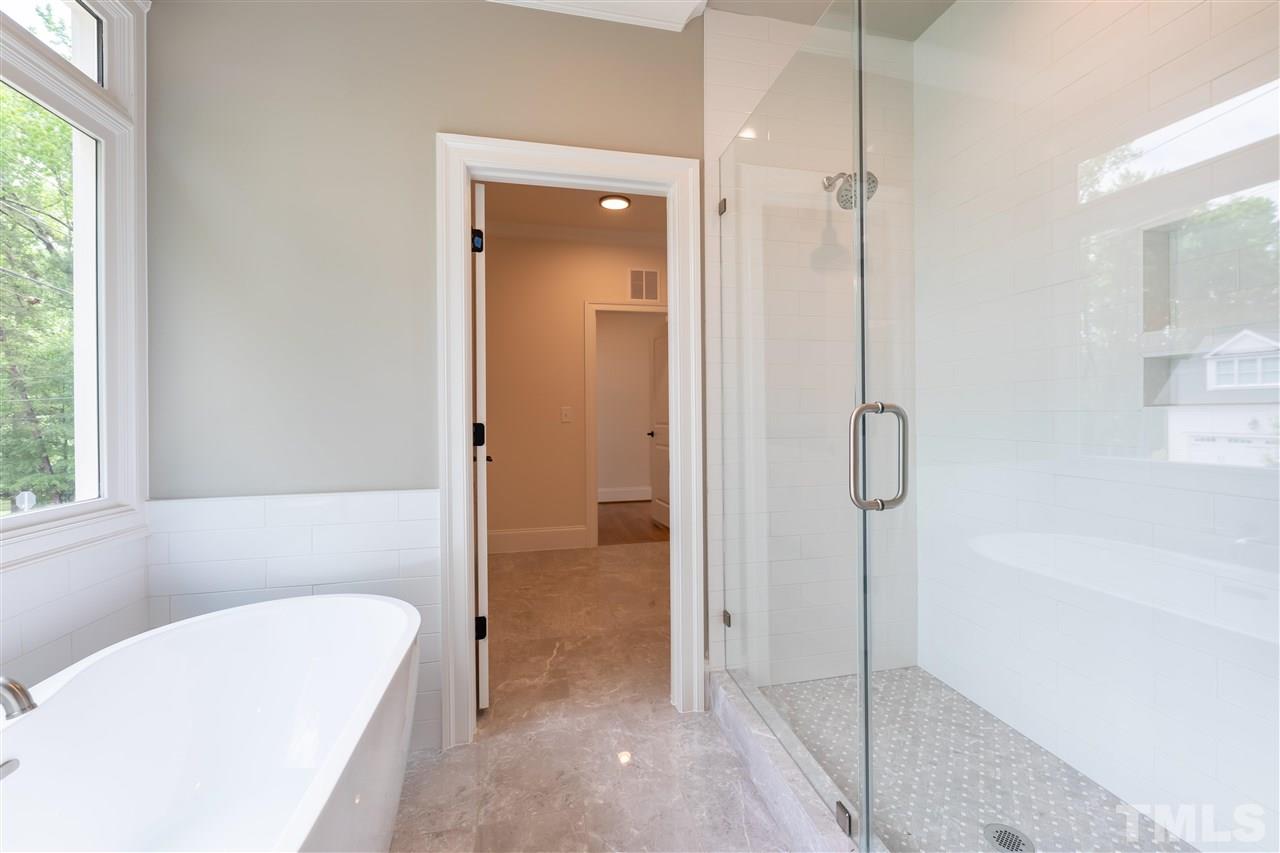 1439 Nottingham Road Raleigh, NC 27607 - Photo 14 of 23 a bathroom with a tub a window and a glass door shower