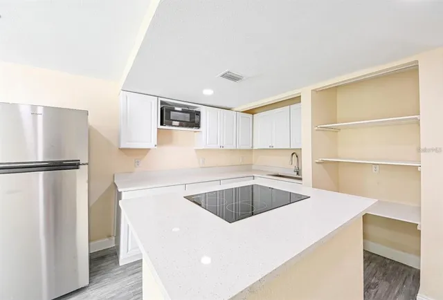 a kitchen with a refrigerator sink and cabinets