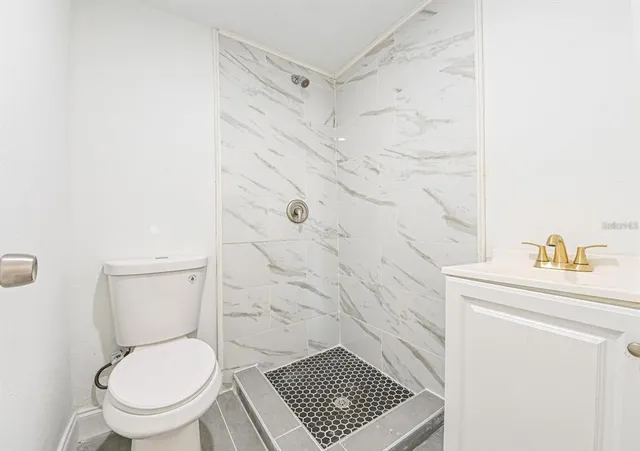 a bathroom with a toilet and a shower