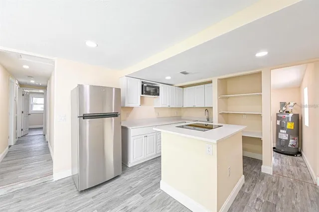 a kitchen with stainless steel appliances granite countertop a refrigerator a stove and a wooden floors