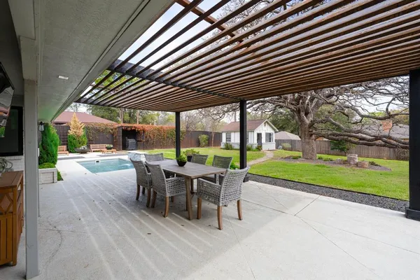 a view of a patio with a table chairs and a backyard