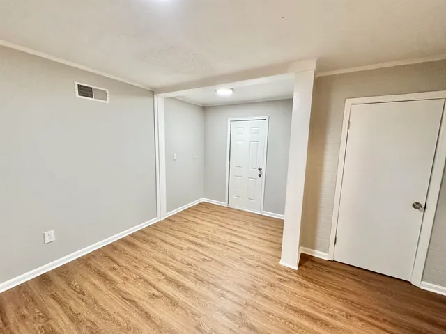 a view of empty room with wooden floor