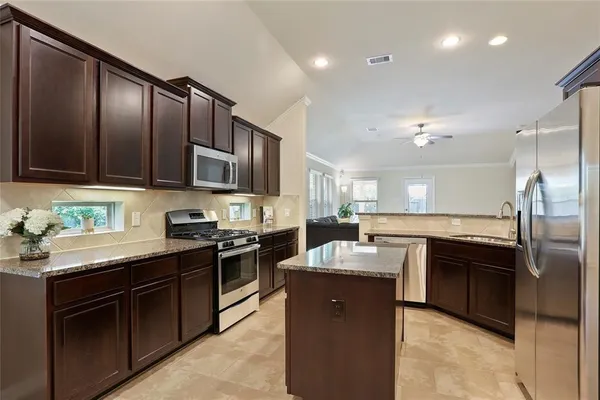 a kitchen with stainless steel appliances granite countertop a sink stove and refrigerator