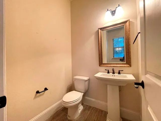 a bathroom with a toilet a sink and mirror