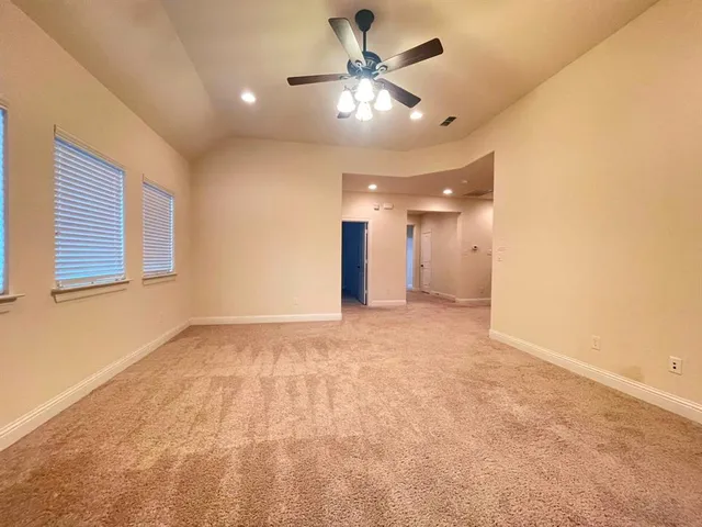 a view of an empty room with a ceiling fan