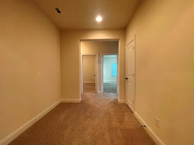 a view of a hallway with wooden shelves