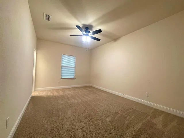 an empty room and a chandelier fan