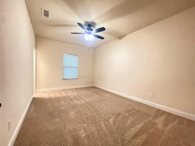 an empty room with windows and fan
