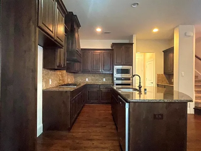 a kitchen with stainless steel appliances granite countertop a sink stove and refrigerator