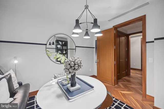 a dining room with wooden floor a chandelier a wooden table and chairs