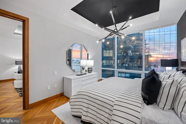 a bedroom with a bed a chandelier and a window