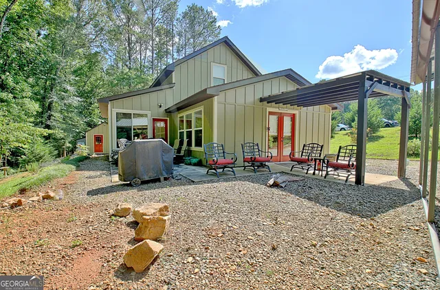 a view of a house with backyard sitting area and glass windows
