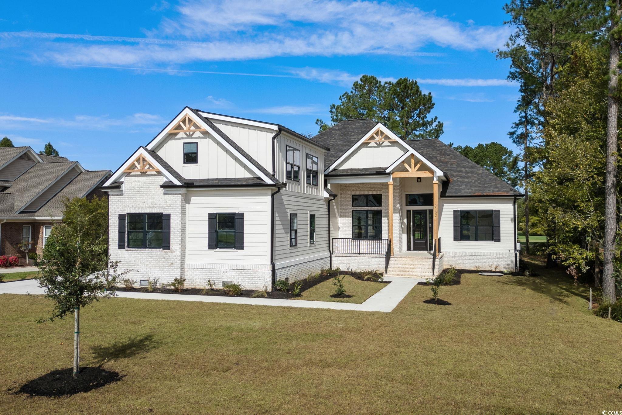 9282 Checkerberry Square Calabash, NC 28467 - Photo 1 of 40 Modern farmhouse style home with a front lawn, board and batten siding, covered porch, and brick siding