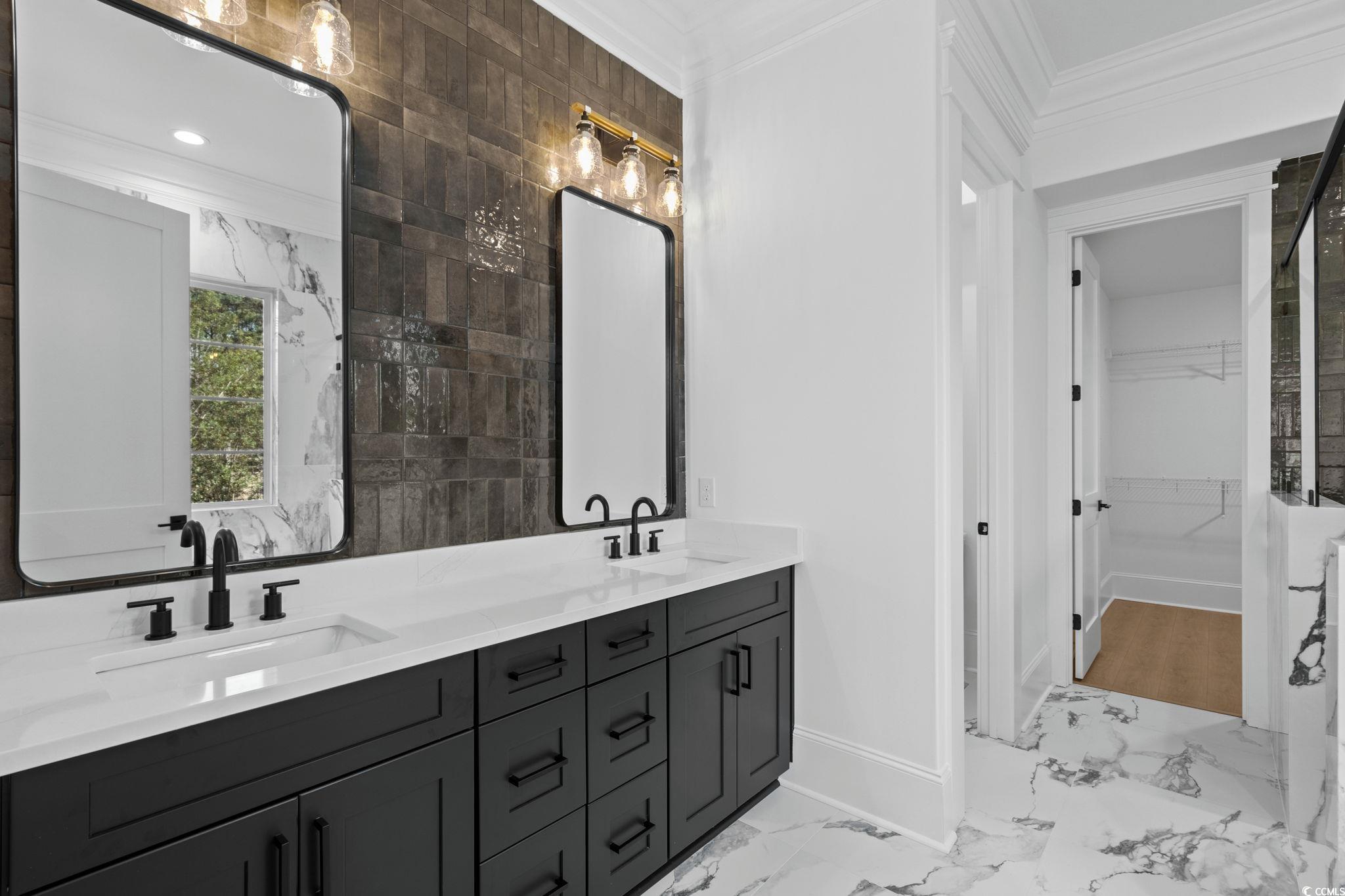 9282 Checkerberry Square Calabash, NC 28467 - Photo 16 of 40 Full bath with ornamental molding, a spacious closet, light marble finish floors, double vanity, and tile walls