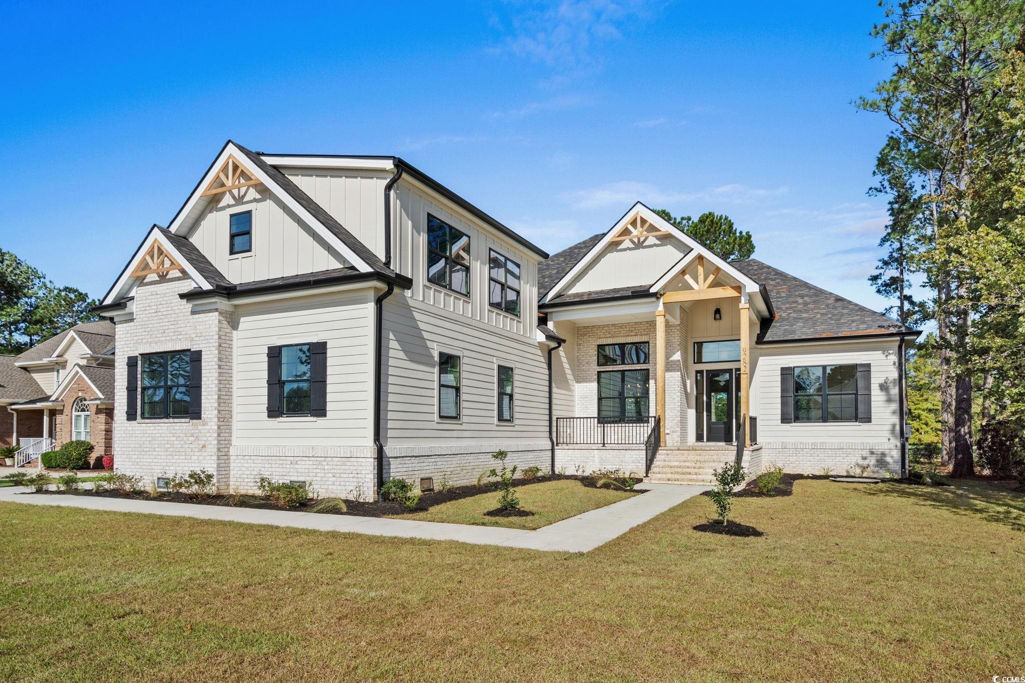 9282 Checkerberry Square Calabash, NC 28467 - Photo 2 of 40 Modern inspired farmhouse with a front yard, board and batten siding, and brick siding