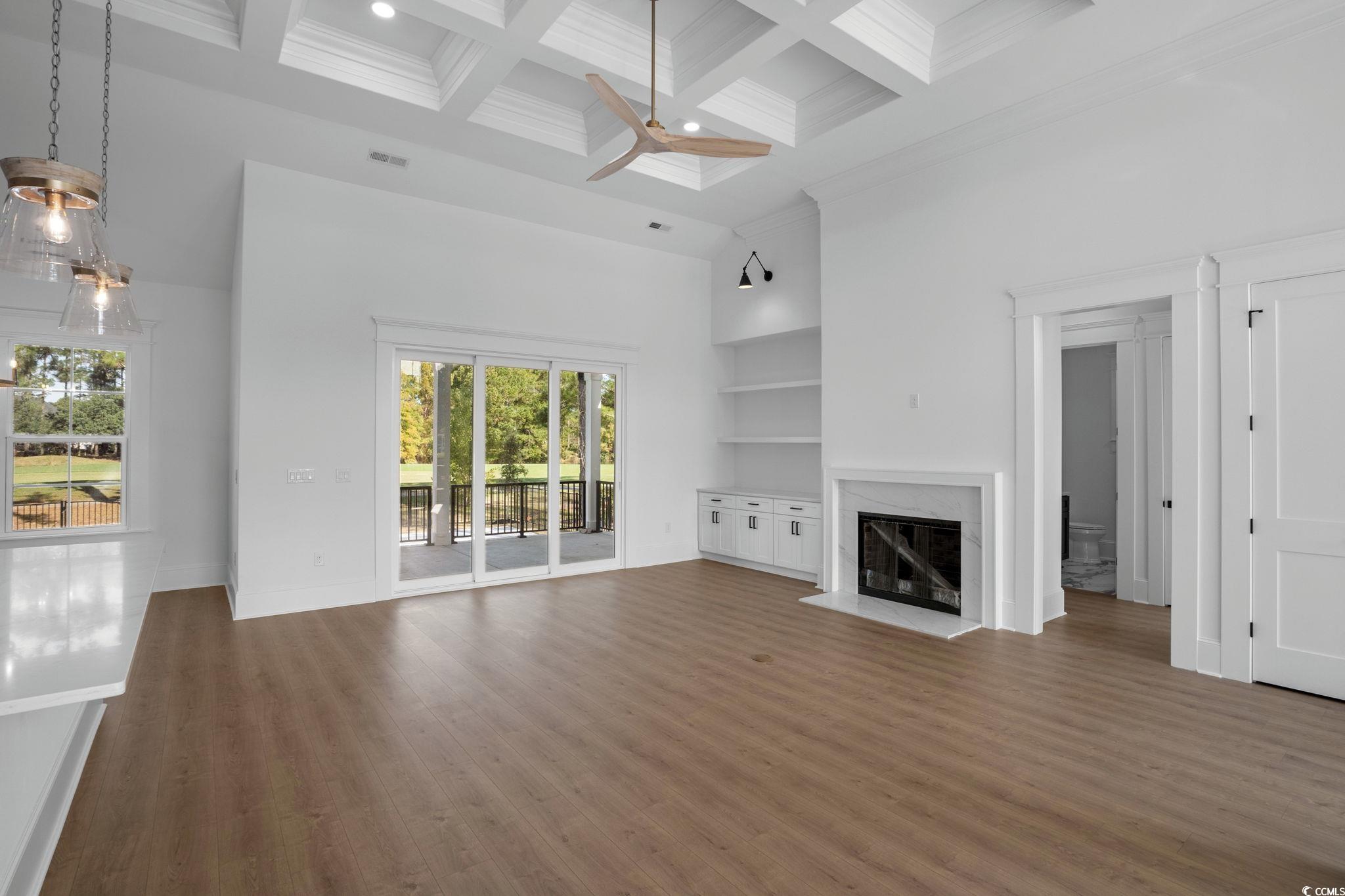 9282 Checkerberry Square Calabash, NC 28467 - Photo 5 of 40 Unfurnished living room with a high ceiling, a high end fireplace, beam ceiling, dark wood finished floors, and built in shelves