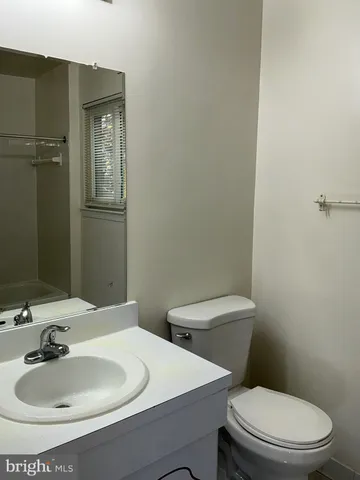 a bathroom with a sink a toilet and mirror