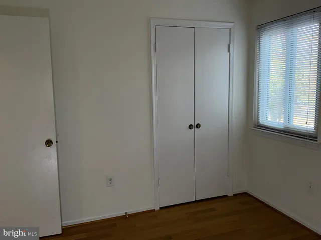 an empty room with wooden floor and a window