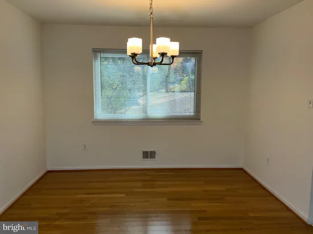 a view of a room with wooden floor and chandelier