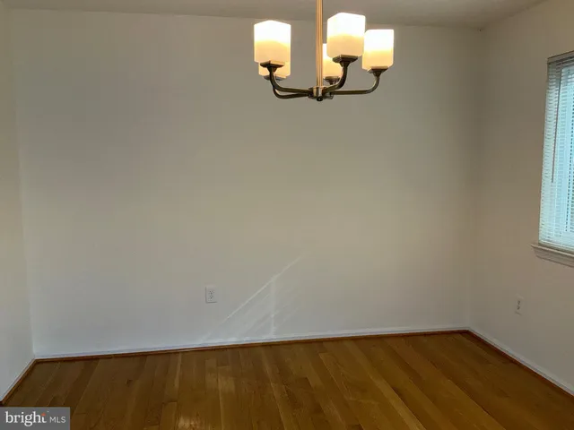 a view of a room with wooden floor and a window