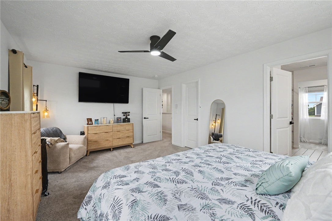 3011 Falls Road Clayton, OH 45315 - Photo 39 of 66 A well-lit bedroom features plush carpeting and a modern ceiling fan for ultimate comfort.