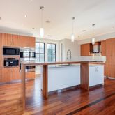 a kitchen with stainless steel appliances granite countertop a refrigerator a stove top oven a sink dishwasher and wooden floor