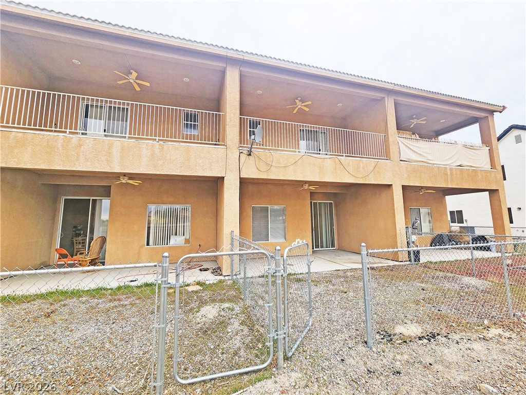 1421 Star Road, Unit 2 Pahrump, NV 89048 - Photo 31 of 33 Rear view of house featuring fence private yard, ceiling fan, stucco siding, and a balcony