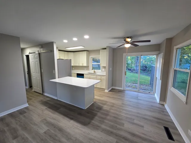 a view of kitchen with refrigerator stove and wooden floor