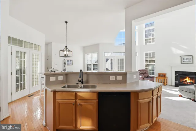 a kitchen with stainless steel appliances granite countertop a sink a stove and a wooden floors