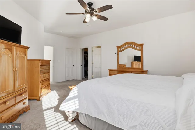 a bedroom with a bed dresser and a flat tv screen