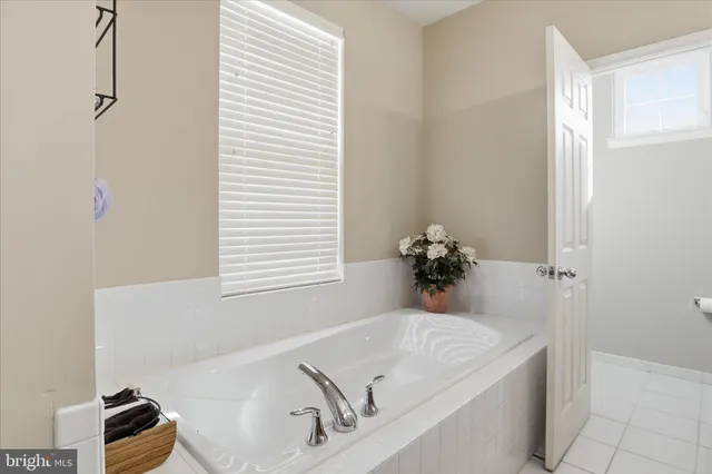 a bath tub sitting in a bathroom next to a window