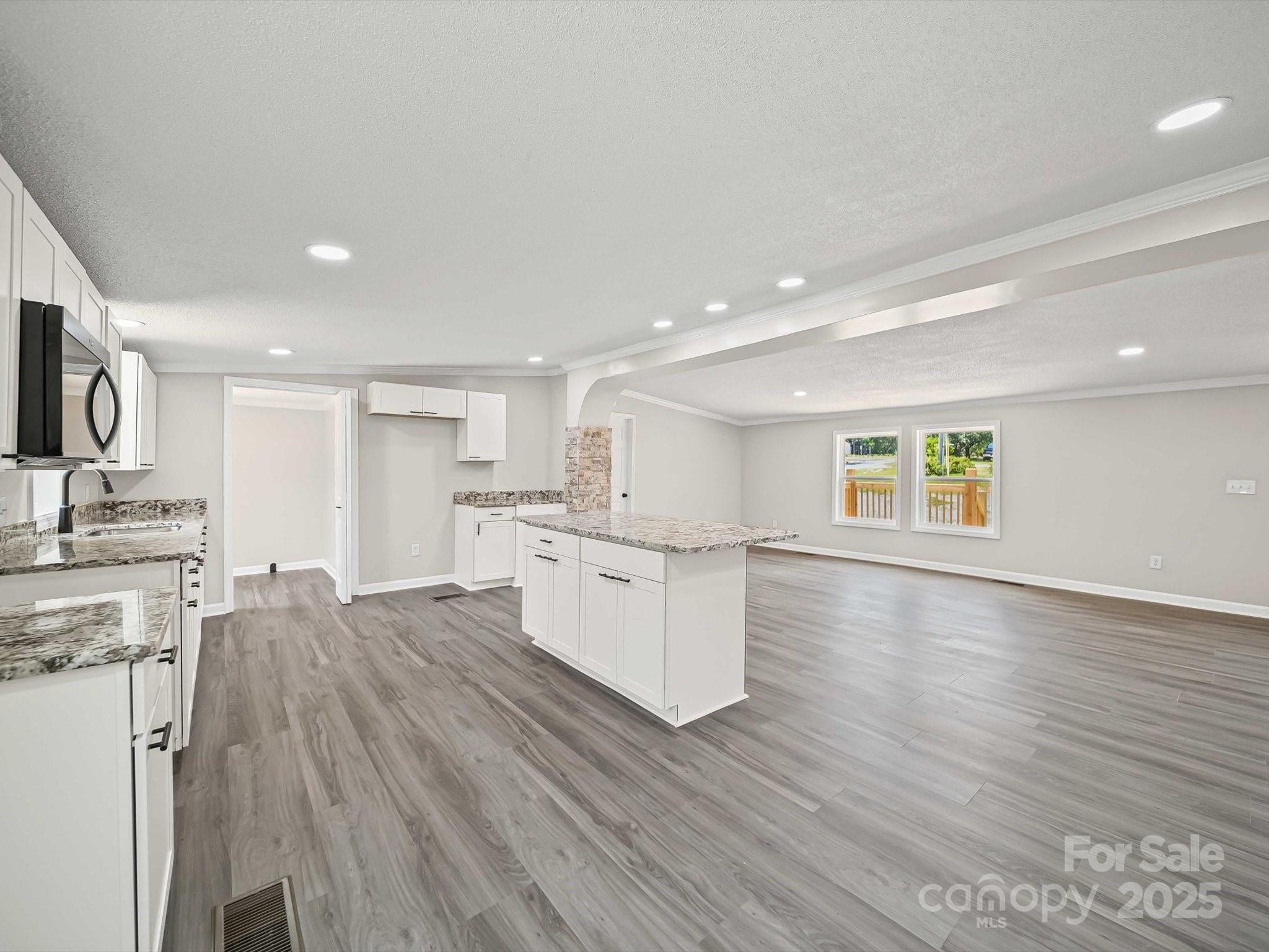 147 Xienghone Road Mount Gilead, NC 27306 - Photo 13 of 22 a large white kitchen with wooden floors and white stainless steel appliances