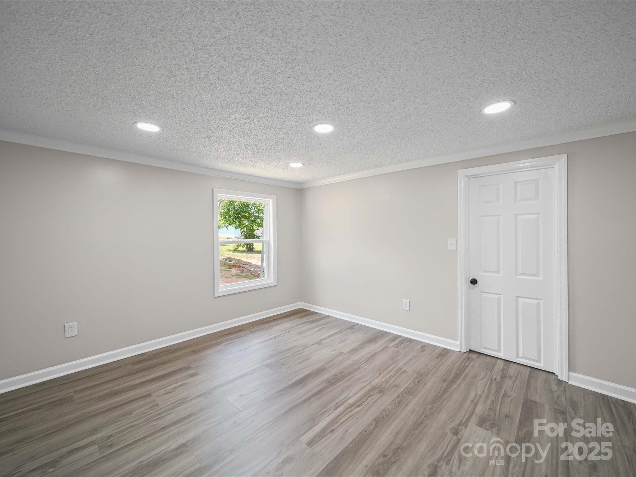 147 Xienghone Road Mount Gilead, NC 27306 - Photo 17 of 22 a view of an empty room with wooden floor and a window