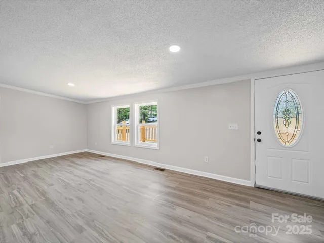 an empty room with wooden floor and window