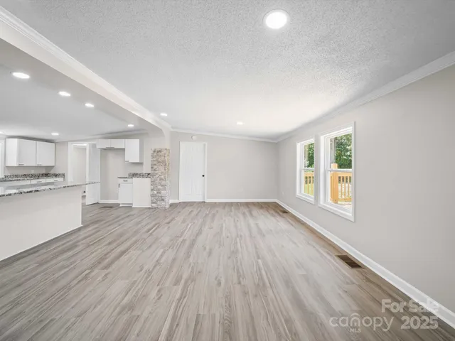 a view of a kitchen with wooden floor and a window
