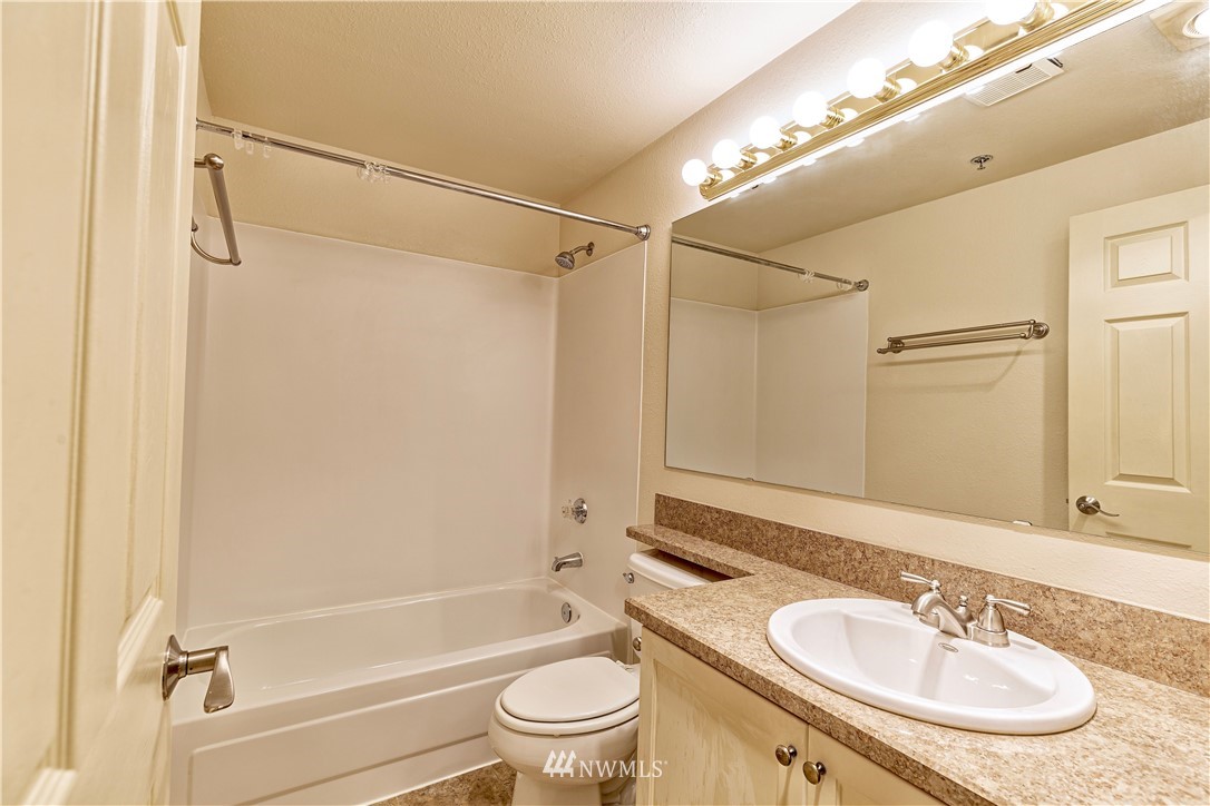 19410 Bothell Way Northeast, Unit D201 Bothell, WA 98011 - Photo 15 of 22 a bathroom with a granite countertop sink toilet and shower