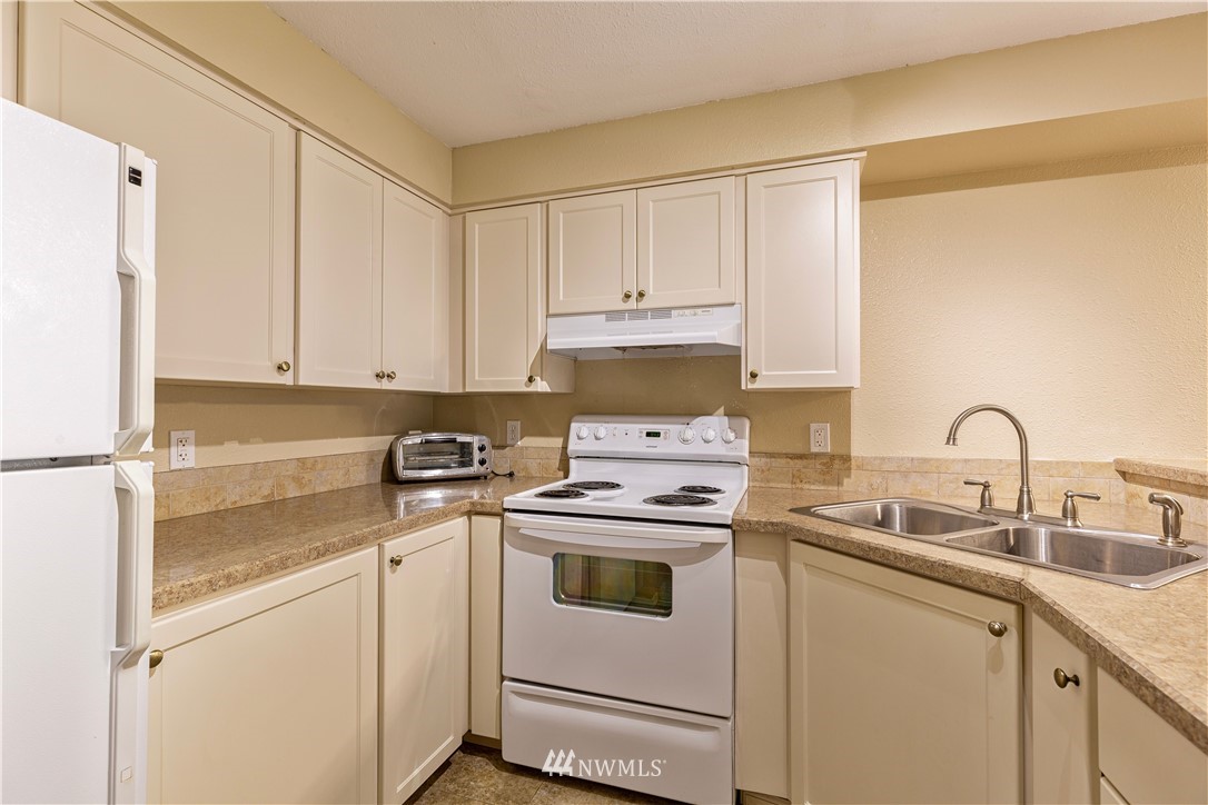 19410 Bothell Way Northeast, Unit D201 Bothell, WA 98011 - Photo 5 of 22 a kitchen with appliances a sink and cabinets