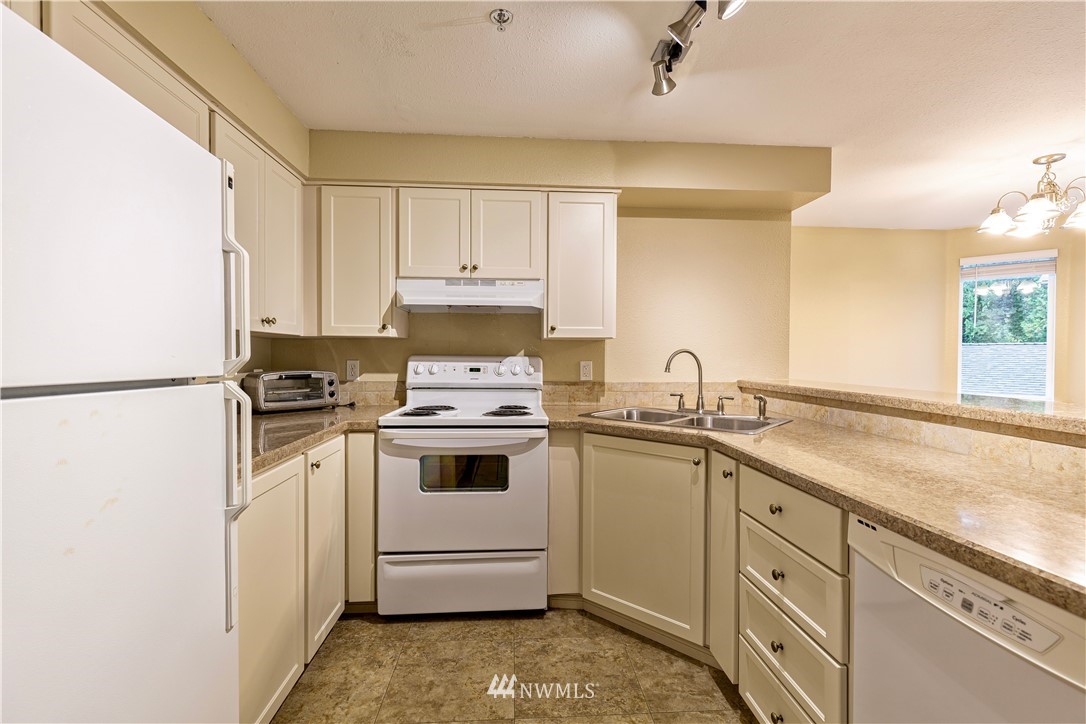 19410 Bothell Way Northeast, Unit D201 Bothell, WA 98011 - Photo 6 of 22 a kitchen with a sink stove and cabinets