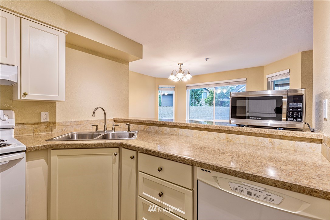 19410 Bothell Way Northeast, Unit D201 Bothell, WA 98011 - Photo 7 of 22 a kitchen with granite countertop a sink and a stove top oven