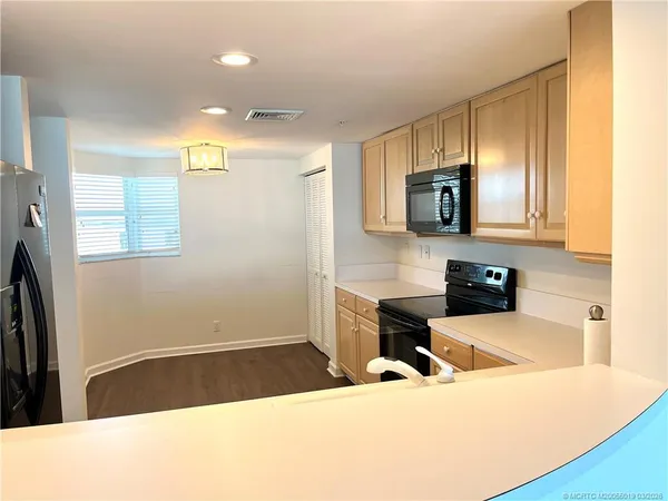 a kitchen with a sink a microwave and cabinets