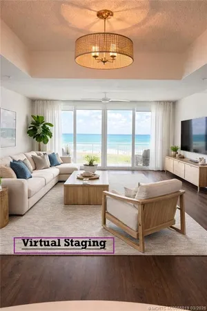 a living room with a large window and a chandelier