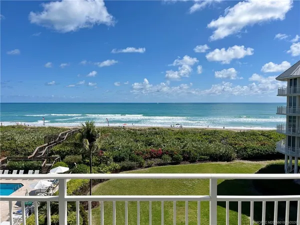 a view of a big yard with an ocean view