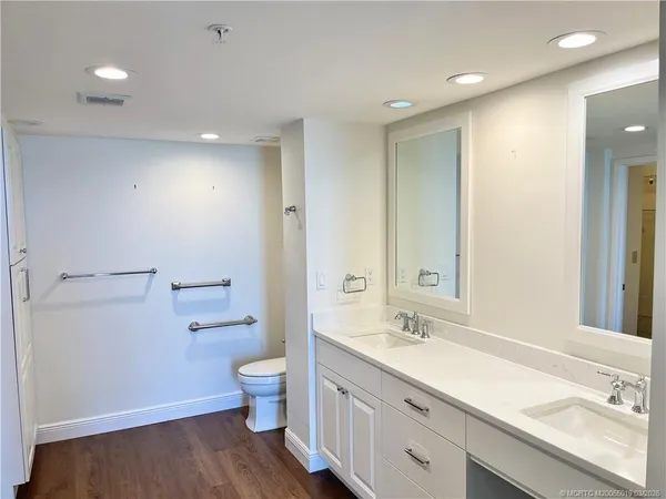 a spacious bathroom with a granite countertop sink a toilet a shower and a mirror