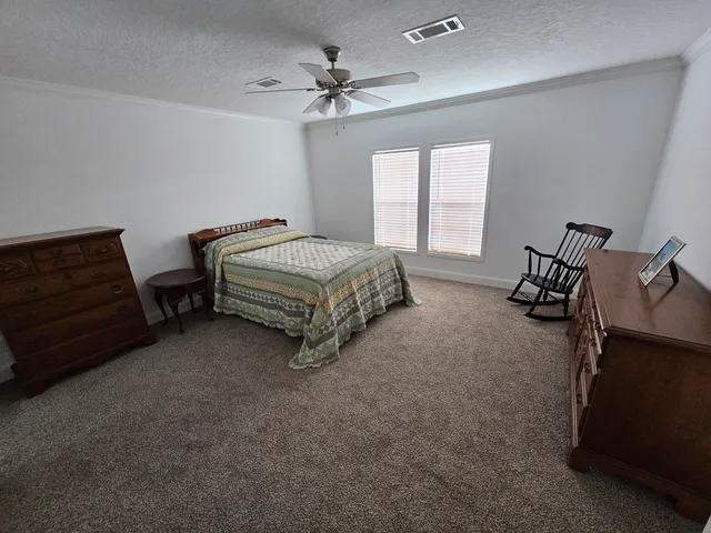 a bedroom with a bed and a ceiling fan